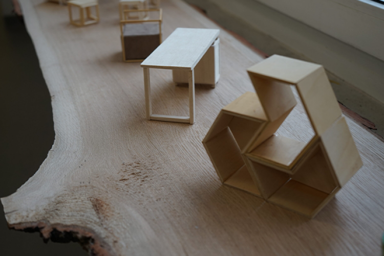 zdjęcie przedstawia małe elementy wykonane z jasnego drewna, takie jak biurko czy półka w kształcie serca. 